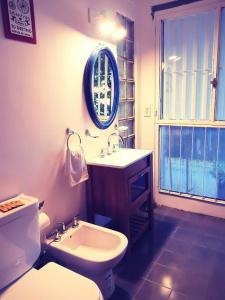 a bathroom with a sink and a toilet and a mirror at La Casa de Malena in Buenos Aires