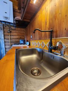eine Edelstahlspüle in einer Küche mit Holzwänden in der Unterkunft Talasuas -aires de montaña in Villa General Belgrano + 34 Fotos