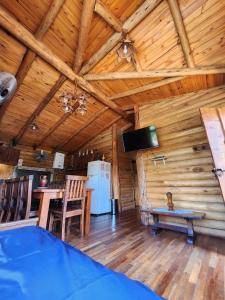 ein Esszimmer und eine Küche in einer Blockhütte in der Unterkunft Talasuas -aires de montaña in Villa General Belgrano