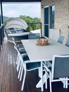 a white dining table and chairs on a deck at Nautilus @Hydeaway Bay/ Hideaway Bay in Hideaway Bay