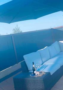 a blue couch with a bottle of wine and glasses at Nautilus @Hydeaway Bay/ Hideaway Bay in Hideaway Bay