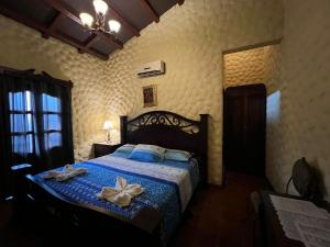 Un dormitorio con una cama con una flor. en Hotel Caxa Real, en Comayagua