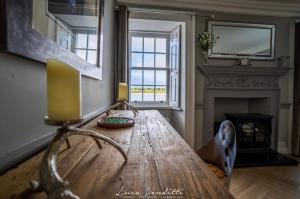 a living room with a wooden table and a fireplace at Findhorn House. Luxury waterfront retreat, the perfect getaway! in Forres +23 photos