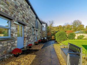 a stone house with a bench in front of it at 4 Bed in Abergavenny 90003 in Gilwern