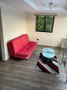 ein Wohnzimmer mit einem roten Sofa und einem Tisch in der Unterkunft Hermoso apartamento en Guatape Antioquia in Guatapé