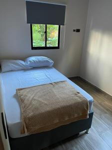 a bedroom with a bed with a window at Hermoso apartamento en Guatape Antioquia in Guatapé