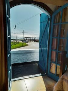an open door to a room with a view of the beach at Brisas Hosteria in Santa Clara del Mar