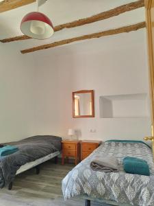 a bedroom with two beds and a dresser and a mirror at kats chulilla in Chulilla