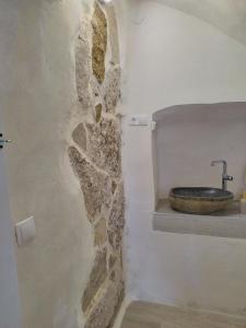a bathroom with a stone wall and a sink at kats chulilla in Chulilla