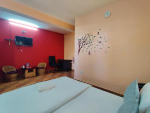 1 dormitorio con cama y pared roja en The Shire Kalimpong, en Kalimpong