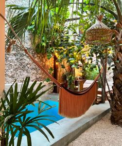 a hammock in the middle of a garden with plants at Japoneza Retreat Mérida Centro in Mérida