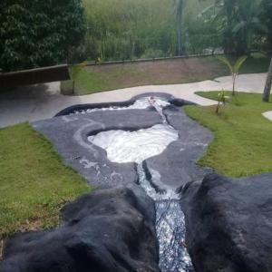 Un río falso con rocas en un patio en Pousada Vila Sol Maior, en Guarapari