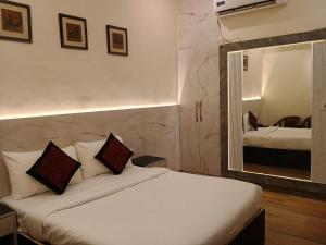グレーター・ノイダにあるStiltstay Hotel, Greater Noidaのベッドと鏡が備わるホテルルーム