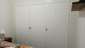 two tall white cabinets in a room with a bed at Ale Belgrano in Mar del Plata