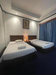 um quarto de hotel com duas camas e uma janela em Sadinah Sahid By Meliala em Kartosuro
