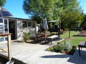 a wooden deck with a picnic table and an umbrella at Tasman Motor Camp in Tasman