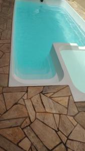 - une piscine avec un sol en pierre et de l'eau bleue dans l'établissement Espaço lazer, à Ribeirão Preto