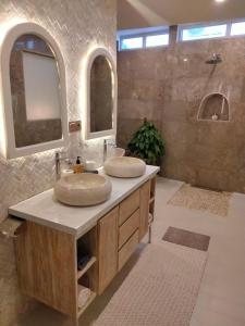 a bathroom with two sinks and two mirrors at Puspa Ayu Villas & Apartments in Kuta