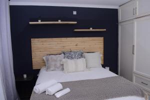 a bedroom with a bed with a blue wall at Kanana Villas in Otse