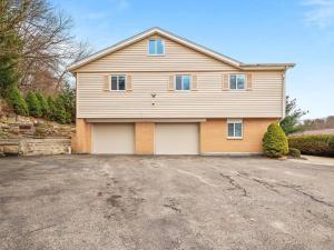 a large house with a garage in a driveway at Modern and Accessible 5 Bedroom Home in Wexford/Pittsburgh with Private Pool in Wexford