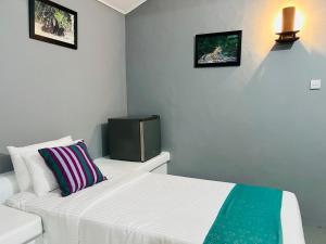 a bedroom with a bed and a tv on the wall at Kingfisher Beach Resort -Yala in Kirinda