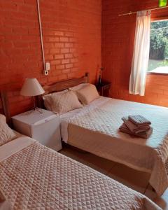 sypialnia z 2 łóżkami i oknem w obiekcie Pousada, Camping e Restaurante do Sô Ito w mieście Santa Rita de Jacutinga