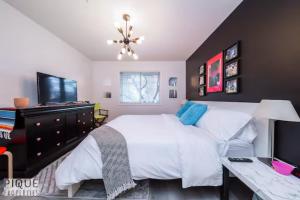 - une chambre avec un grand lit blanc et un bureau dans l'établissement The Neon Palace - KingBed - Fireplace - Netflix - UG Park, à Edmonton