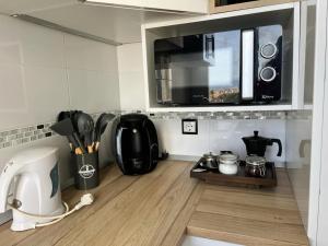 a kitchen with a coffee maker and a microwave at Espectacular apartamento junto al mar, con piscina en Málaga in Málaga