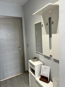 baño con lavabo, espejo y puerta en Espectacular apartamento junto al mar, con piscina en Málaga, en Málaga