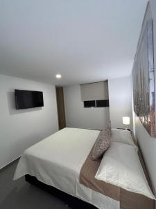 a bedroom with a bed and a tv on the wall at Apto cerca a la 10 del poblado in Medellín