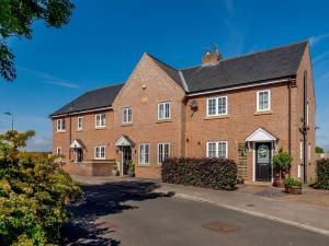 una grande casa in mattoni rossi con tetto nero di 3 bed in Malton 78311 a Kirby Misperton