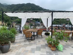 a patio with a table and chairs under a white canopy at Beijing MutianyuGreat Wall Let'sgo coffee&homesty in Huairou