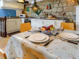a kitchen with a table with plates and a bowl of fruit at 2 bed in Brailsford PK816 in Brailsford +12 photos