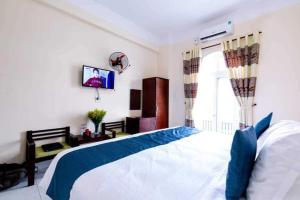Un dormitorio con una cama y un televisor en la pared. en Zone 5 Boutique Hotel, en Da Nang