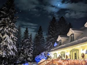 une maison recouverte de lumières de Noël dans la neige dans l'établissement La Tremblante, à Mont-Tremblant