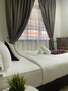 - une chambre avec un grand lit blanc et une fenêtre dans l'établissement THREE ROOMS WITH WIFI HOMESTAY D’RAZAK IN KUALA TERENGGANU, à Kuala Terengganu