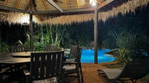 a patio with a table and chairs and a pool at Paperbark Retreat in Cooktown