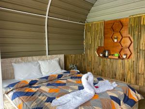a bedroom with a bed with two towels on it at Bali Strawberry Glamping and Camp Bedugul in Tabanan