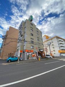a building on a street with cars parked in front of it at 【NEW OPEN】AMS Hiragishi 402 in Sapporo