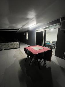 ein dunkles Zimmer mit einem Tisch in der Mitte eines Zimmers in der Unterkunft Stay 'n Go - Raiatea in Uturoa