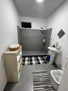 een badkamer met een douche, een wastafel en een toilet bij Stay 'n Go - Raiatea in Uturoa