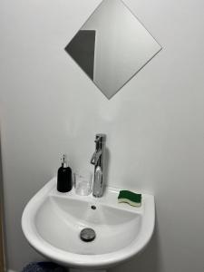 ein weißes Waschbecken mit einem Spiegel darüber in der Unterkunft Stay 'n Go - Raiatea in Uturoa