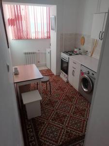 une petite cuisine avec une table et un lave-linge. dans l'établissement 3 дом вид на море, à Aktau