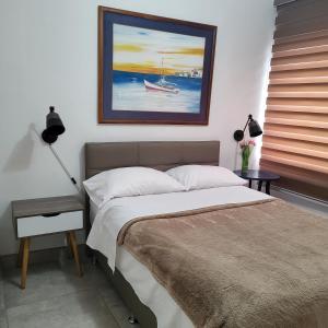 a bedroom with a bed and a painting of a boat at Mi Lido Chalet in El Morro de Barcelona
