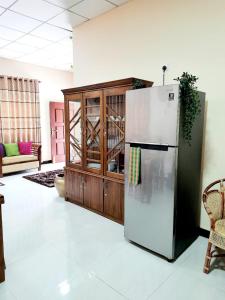a kitchen with a refrigerator and a wooden cabinet at Happy Nest in Talagala