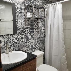 a bathroom with a sink and a shower curtain at Mi Lido Chalet in El Morro de Barcelona