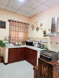 La cuisine est équipée de placards en bois et d'un four avec plaques de cuisson. dans l'établissement Happy Nest, à Talagala