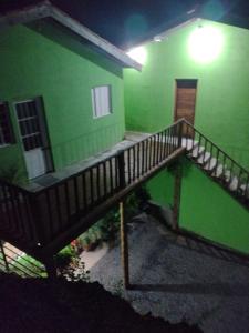 a green building with a staircase in front of it at Chale 8A in Cunha