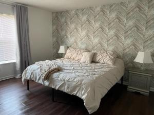 1 dormitorio con 1 cama con pared a rayas en Haven - Uptown/Airport Corridor en Charlotte