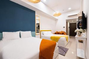 a bedroom with two beds and a blue wall at Genius Apartment River Gate Free Pool in Ho Chi Minh City